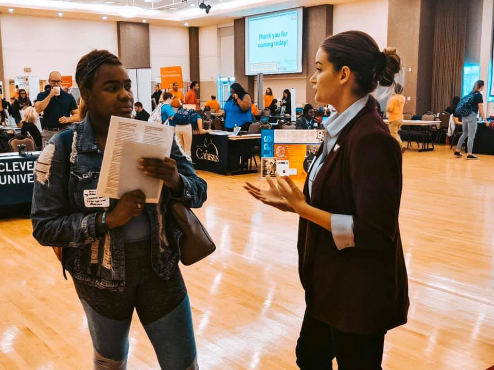 a center for emerging media design and development representative discusses the program with a prospective student