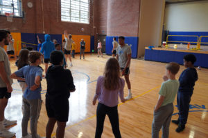 UCLA players teaching students how to set, pass, and hit